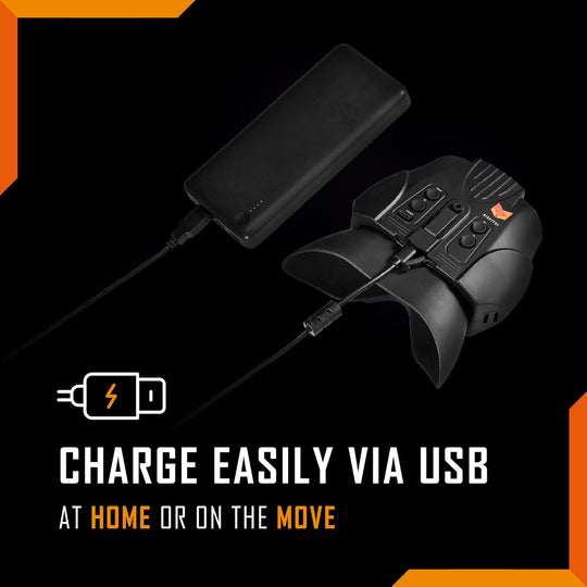 Black electronic night vision device with USB cable on a black background with orange accents.